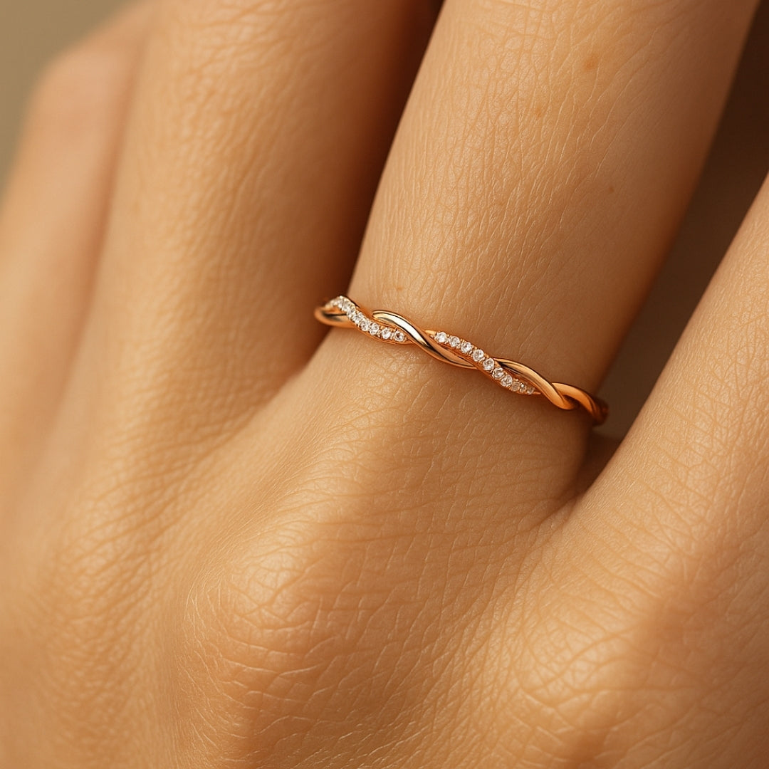 Anillo fino trenzado en tono rosado con circonitas