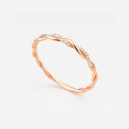 Anillo fino trenzado en tono rosado con circonitas